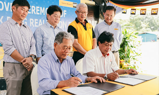 Sales Director of Tractors Malaysia, Azlan Ismail (seated right) and Datuk Toh Chiew Hock, Managing Director of Hock Peng Group (seated left) inking the deal at the signing ceremony.